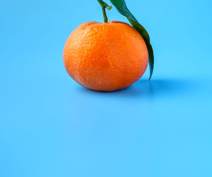 a pic of an orange with a blue background color 